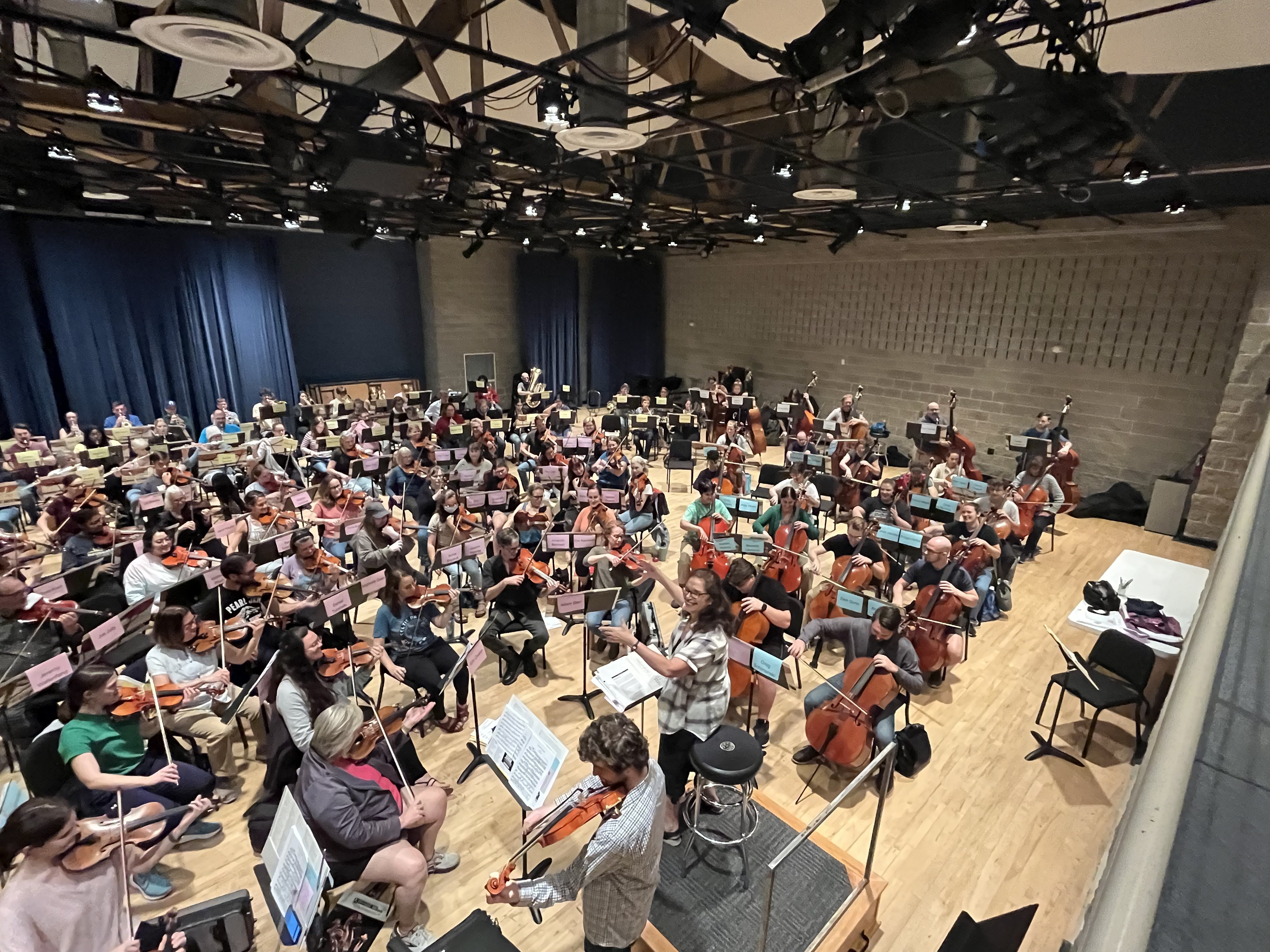 Rehearsal photo of Milwaukee Community Orchestra, taken from above and showing most of the ensemble